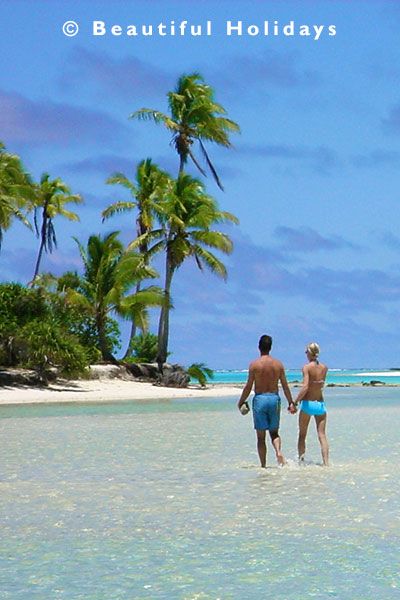 couple stroll in the lagoon off One Foot Island in Aitutaki